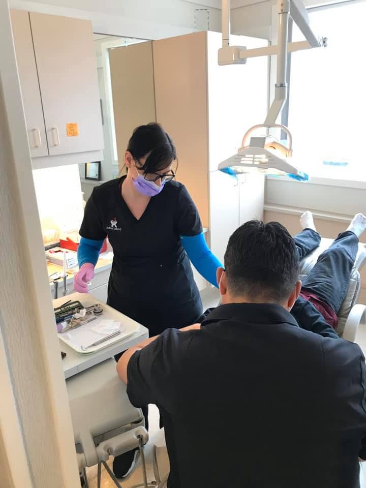 A Dene Dental team member caring for a patient in the treatment chair